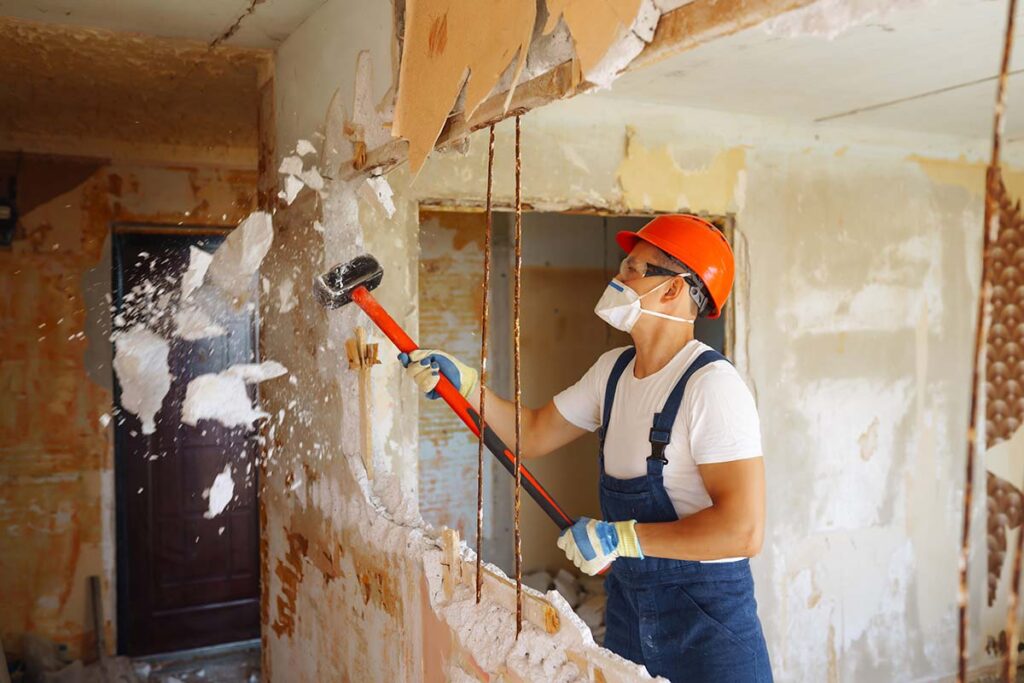 Young Male Builder In Hard Hat Holding Tools. Apartment Repair And Renovation Concept.