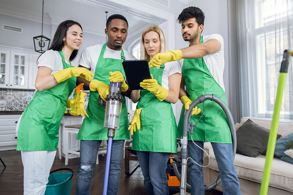 Pleasant Concentrated Mature Blond Woman Giving Commands To Her Cleaning Staff, Showing The Plan Of Luxury Appartments On Tablet Pc